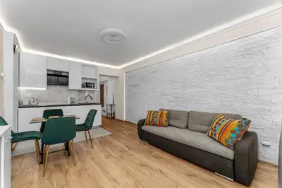 a living room with a couch and a kitchen at Sereno Vista Apartment by BookingHost in Kraków