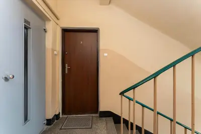 a hallway with a wooden door in a building at Sereno Vista Apartment by BookingHost in Kraków