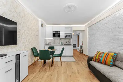 a living room with a couch and a table and chairs at Sereno Vista Apartment by BookingHost in Kraków