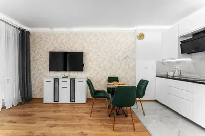 a kitchen and dining room with a table and chairs at Sereno Vista Apartment by BookingHost in Kraków