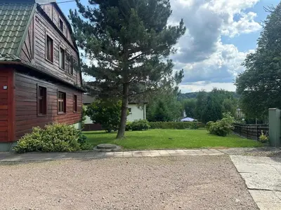 a house with a tree in front of a yard at Parkowa Apartment in Wadowice