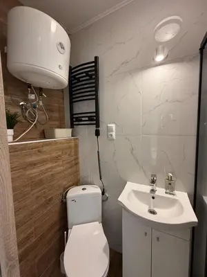 a bathroom with a white toilet and a sink at Parkowa Apartment in Wadowice