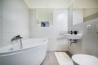 a bathroom with a tub and a toilet and a sink at Elegancki apartament - Kalwaryjska, centrum Krakowa in Kraków