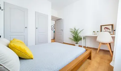 a living room with a couch and a kitchen at Elegancki apartament - Kalwaryjska, centrum Krakowa in Kraków