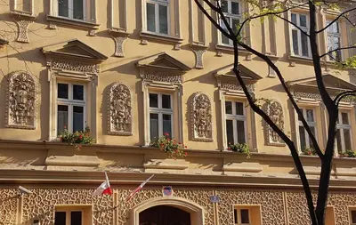 a yellow building with windows and flowers on it at Homely Apartment's Old Town in Kraków