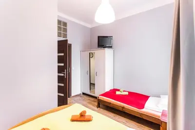 a small room with a bed and a mirror at Homely Apartment's Old Town in Kraków