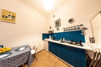 a kitchen with a sink and a blue tile wall at Homely Apartment's Old Town in Kraków
