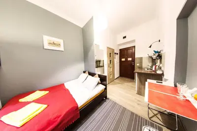 a hotel room with a bed with a red blanket at Homely Apartment's Old Town in Kraków