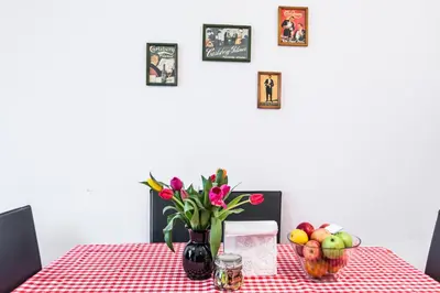 a table with a vase of flowers and fruit on it at Homely Apartment's Old Town in Kraków