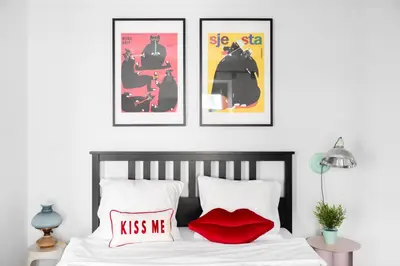 a bedroom with three posters and a bed with red pillows at Old Town Krupnicza in Kraków
