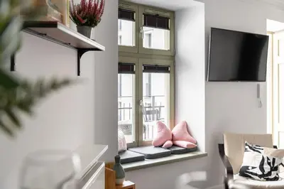 a living room with a window seat with pink pillows at Old Town Krupnicza in Kraków