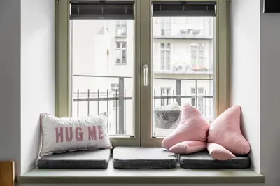 a window seat with pink pillows and a hug me pillow at Old Town Krupnicza in Kraków