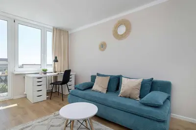 a living room with a blue couch and a table at High Apartment with a View of the Old Town by Noclegi Renters in Kraków