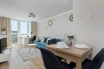 a living room with a table and a blue couch at High Apartment with a View of the Old Town by Noclegi Renters in Kraków
