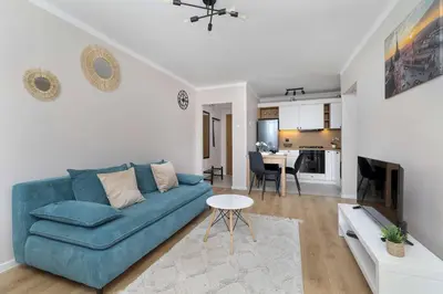 a living room with a blue couch and a table at High Apartment with a View of the Old Town by Noclegi Renters in Kraków