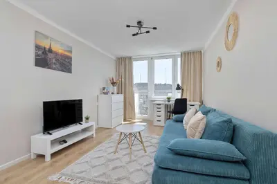a living room with a blue couch and a tv at High Apartment with a View of the Old Town by Noclegi Renters in Kraków