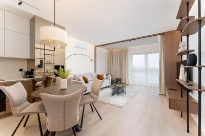 a dining room and living room with a table and chairs at Cracow Novum Apartments by BookingHost in Kraków
