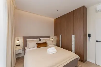 a bedroom with a large bed with a wooden headboard at Cracow Novum Apartments by BookingHost in Kraków