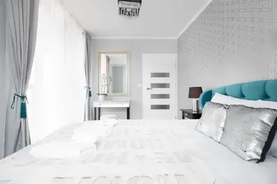 a bedroom with a large white bed with a blue headboard at Two-Bedroom Apartment with Living Room, Free Parking - Kazimierz in Kraków