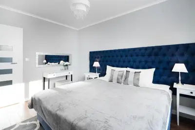 a bedroom with a large bed with a blue headboard at Two-Bedroom Apartment with Living Room, Free Parking - Kazimierz in Kraków