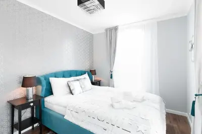 a bedroom with a blue and white bed and a window at Two-Bedroom Apartment with Living Room, Free Parking - Kazimierz in Kraków