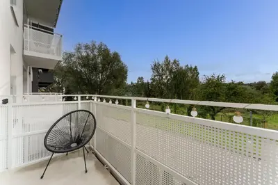 a chair sitting on the balcony of a building at Walerego Sławka Harmony Apartment by BookingHost in Kraków