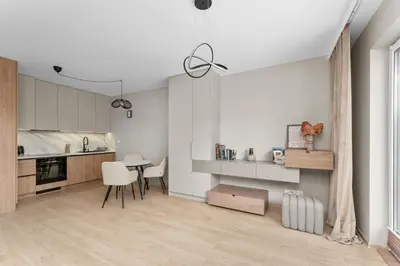 a kitchen with white cabinets and a table and chairs at Walerego Sławka Harmony Apartment by BookingHost in Kraków