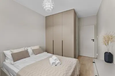 a bedroom with a bed with two white towels on it at Walerego Sławka Harmony Apartment by BookingHost in Kraków