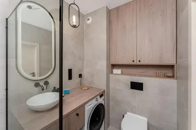 a bathroom with a sink and a washing machine at Walerego Sławka Harmony Apartment by BookingHost in Kraków