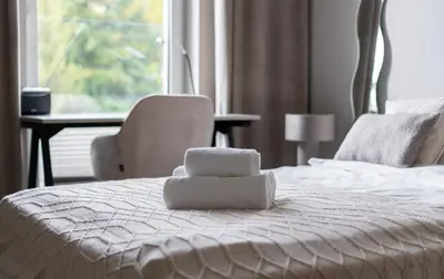 a white bed with a pile of towels on it at Walerego Sławka Harmony Apartment by BookingHost in Kraków