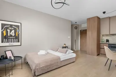 a white bedroom with a bed and a kitchen at Walerego Sławka Harmony Apartment by BookingHost in Kraków