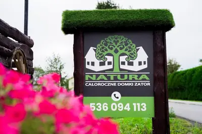 a sign for a garden with pink flowers at Domki Natura Zator in Graboszyce