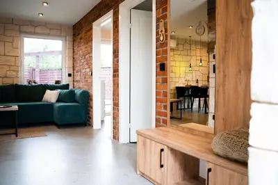 a living room with a green couch and a brick wall at Domki Natura Zator in Graboszyce