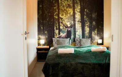 a bedroom with a bed with a deer on the wall at Domki Natura Zator in Graboszyce