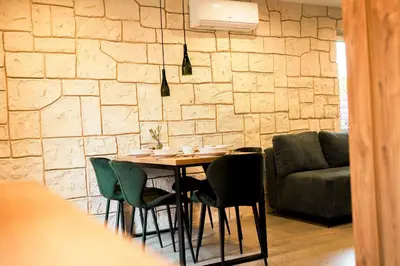 a dining room with a table and chairs and a couch at Domki Natura Zator in Graboszyce