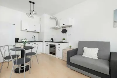 a kitchen and a living room with a couch and a table at Bright Studio in Cracow with Desk and Bathtub by Noclegi Renters in Kraków