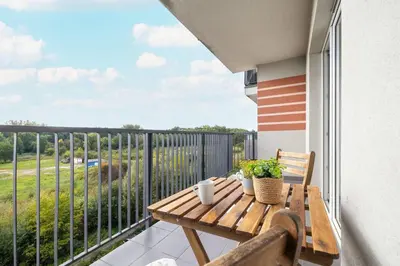 a wooden table on a balcony with a view at Bright Studio in Cracow with Desk and Bathtub by Noclegi Renters in Kraków