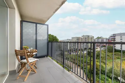 a balcony with a chair and a view of a city at Bright Studio in Cracow with Desk and Bathtub by Noclegi Renters in Kraków