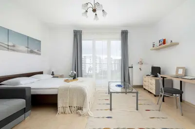 a bedroom with a bed and a desk and a chair at Bright Studio in Cracow with Desk and Bathtub by Noclegi Renters in Kraków