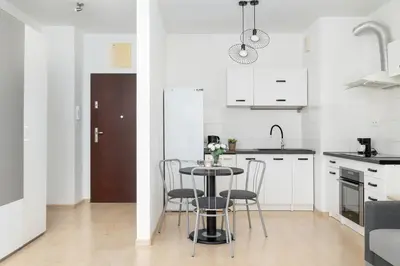 a kitchen with a table and chairs in a room at Bright Studio in Cracow with Desk and Bathtub by Noclegi Renters in Kraków