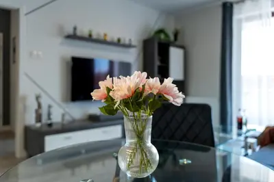 a vase filled with pink flowers on a glass table at Kaskada in Kraków