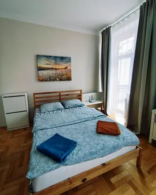 a bedroom with a large bed with blue sheets at Krakow City Stay Vintage in Kraków