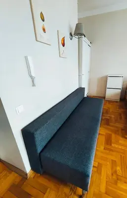 a blue couch in a room with a white wall at Krakow City Stay Vintage in Kraków