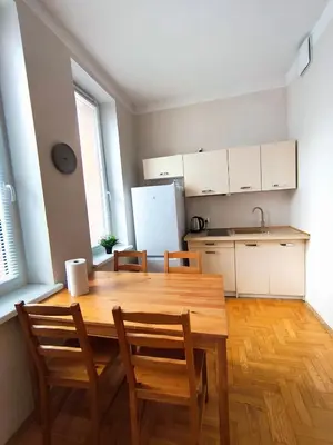 a kitchen with a wooden table and chairs in a room at Krakow City Stay Vintage in Kraków