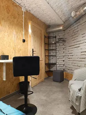 a room with a black chair and a brick wall at Room 1 industrial in Kraków
