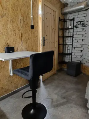 a black chair sitting in a room with a desk at Room 1 industrial in Kraków