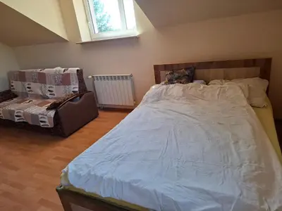 a bedroom with a large bed and a chair at Pokoje u Zbigniewa