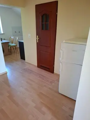 a kitchen with a white refrigerator and a wooden door at Pokoje u Zbigniewa