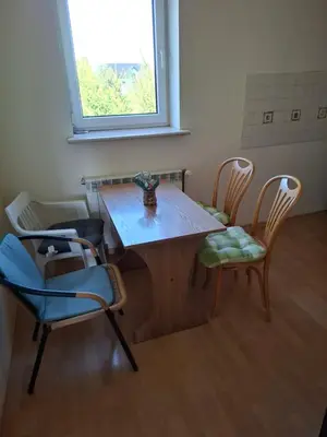 a table and chairs in a room with a window at Pokoje u Zbigniewa