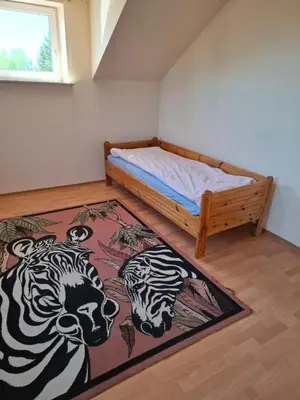 a bedroom with a bed and a rug on the floor at Pokoje u Zbigniewa